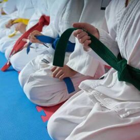 Personen im Judo Anzug mit verschieden farbigen Gürteln